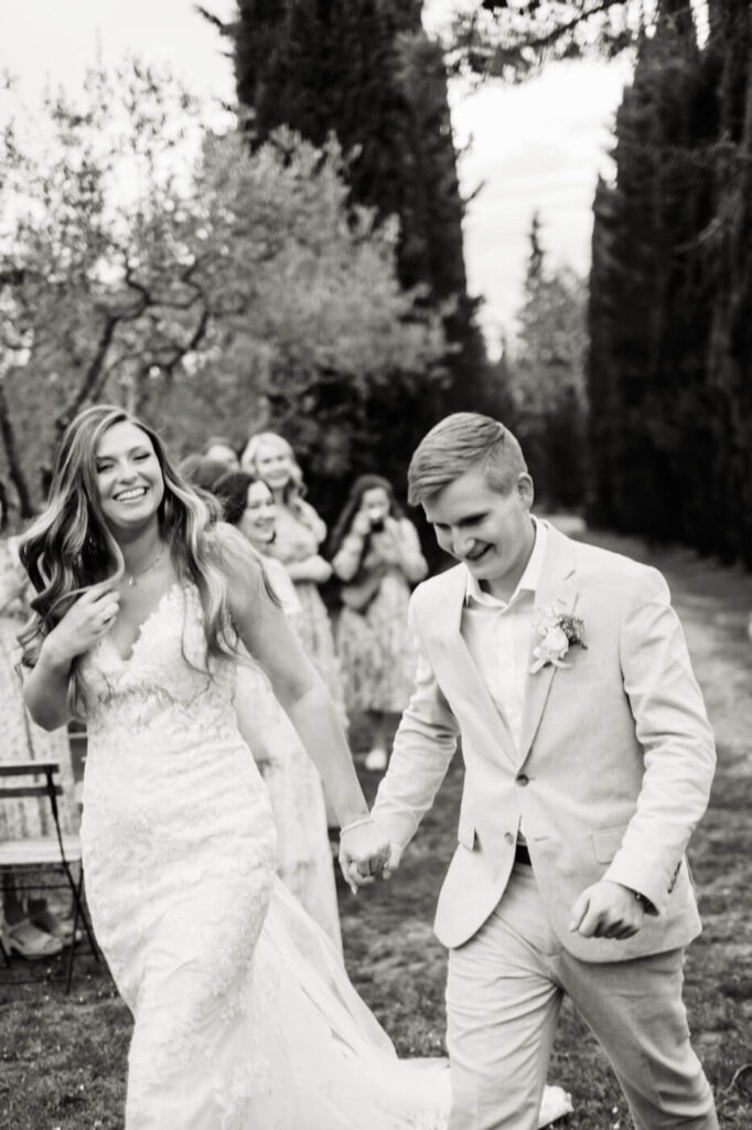 Pure just-married joy – The bride and groom walk hand-in-hand down the aisle, laughter on their lips as their guests celebrate their union.