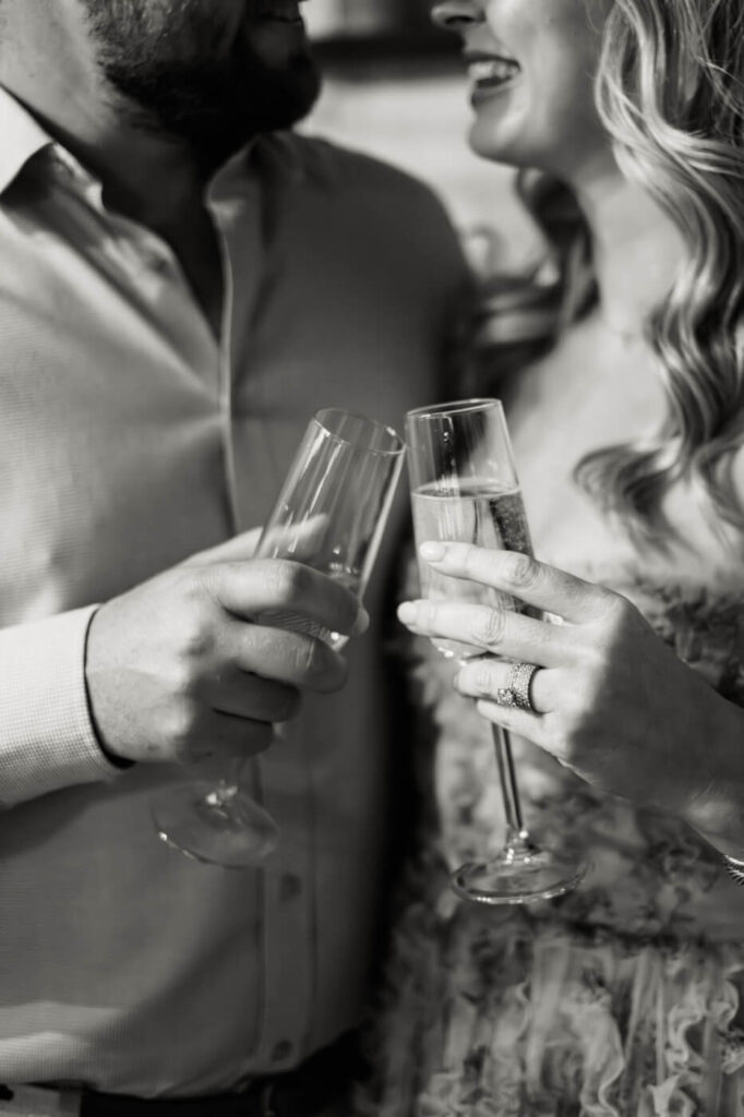 A toast to forever – Clinking champagne glasses, a close-up of hands intertwined, a quiet moment of celebration between loved ones.