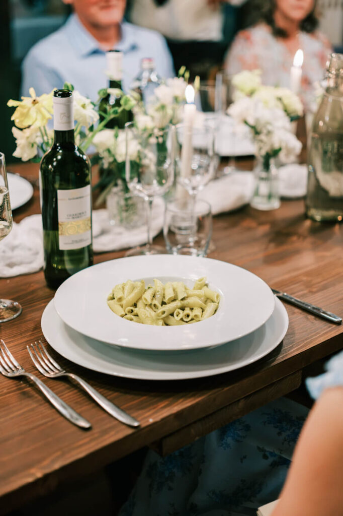 A taste of Tuscany – A simple yet elegant plate of pesto pasta is served, a nod to the rich flavors of an authentic Italian wedding feast.