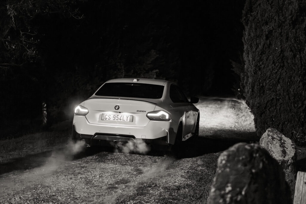 Getaway moment: The couple’s car departs into the Tuscan night – A white BMW drives down a tree-lined path, its taillights glowing and a trail of mist rising in the cool night air.