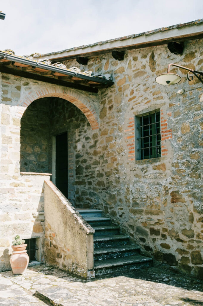 A rustic stone staircase and arched entryway at Villa Olimpia, a historic Tuscan villa perfect for an elegant wedding.