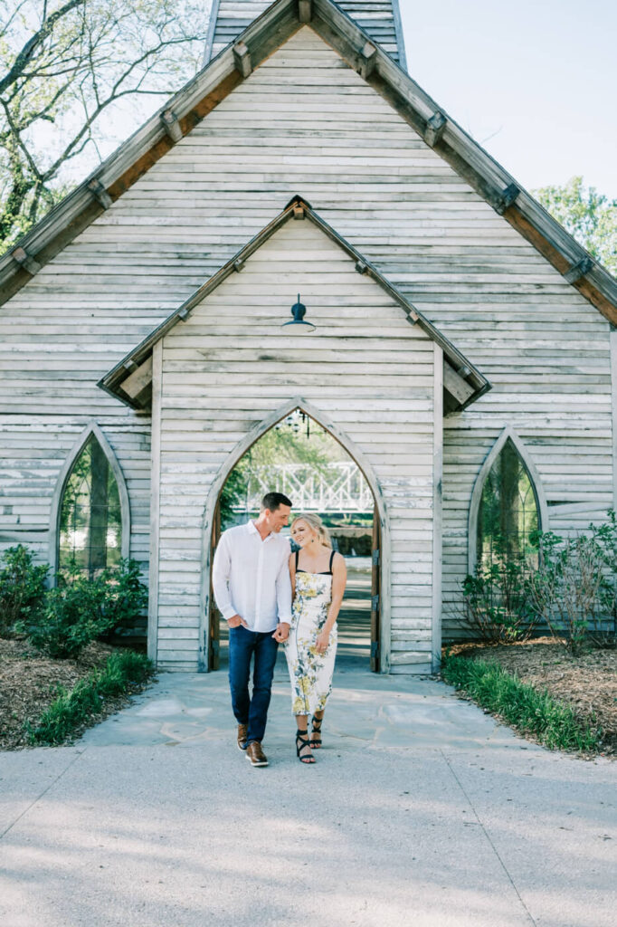 Kandis and Andrew walking hand in hand near the chapel – The couple strolls outside the rustic chapel at Finley Farms, glowing with excitement before their wedding celebration.