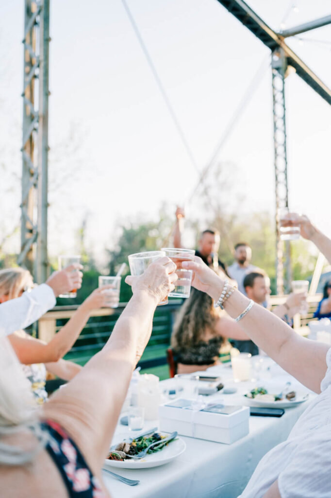 Guests Raising Toasts at Finley Farm Bridge Rehearsal Dinner Celebration – A joyful moment as guests raise their glasses in a heartfelt toast to the couple.