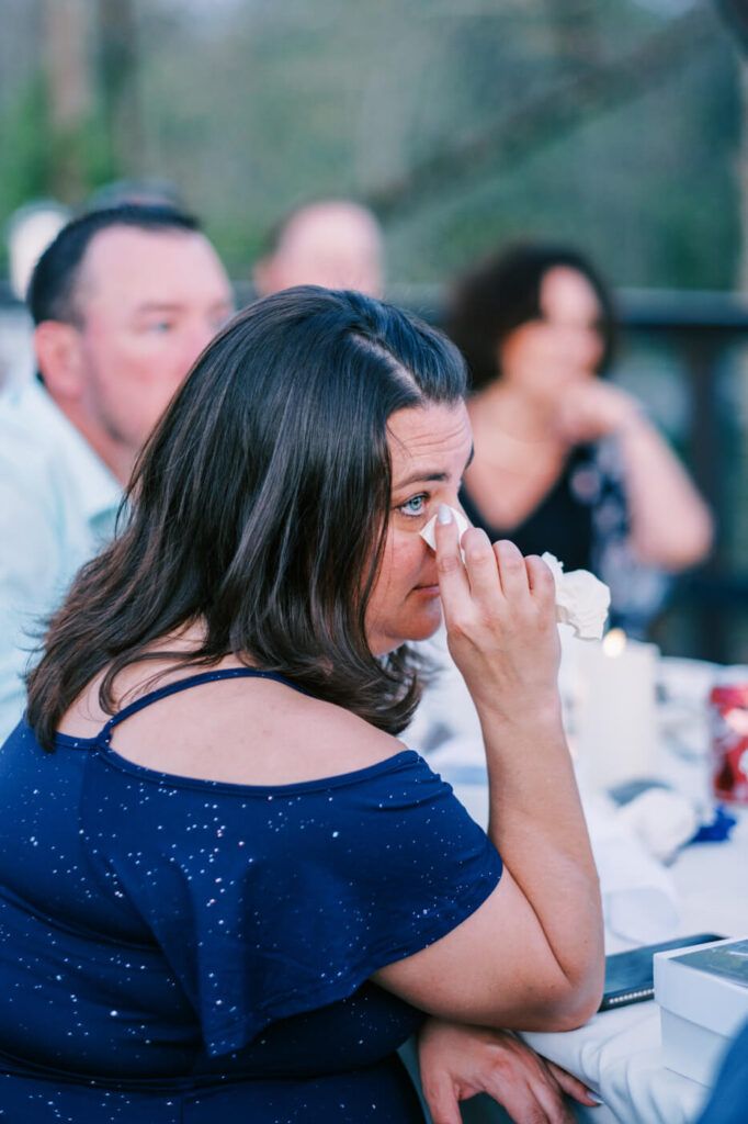 Wedding Guest Wiping a Tear During Toast at Finley Farm Bridge Rehearsal Dinner – A touching moment as a guest wipes away tears of joy during an emotional toast at Finley Farm Bridge.