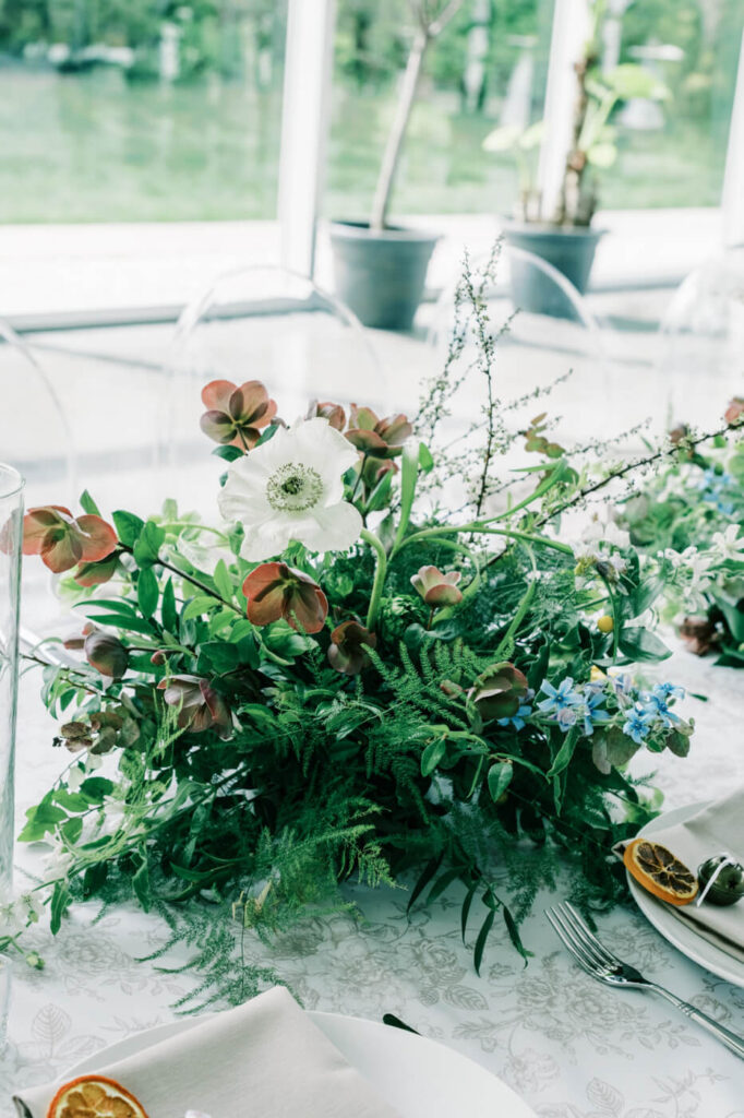 Organic wedding centerpiece with white anemones at Two Rivers Greenhouse – A romantic, nature-inspired centerpiece featuring white anemones, rich greenery, and delicate accents, beautifully complementing the greenhouse ambiance of Two Rivers.