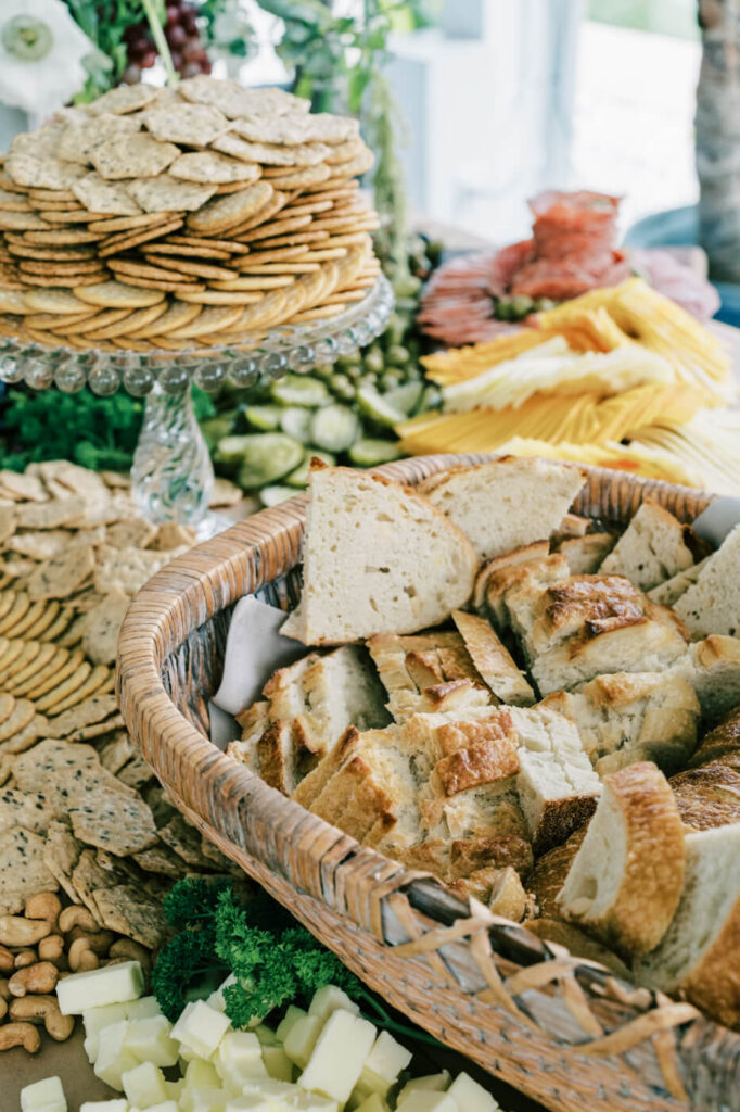 Charcuterie spread at Greenhouse Two Rivers wedding reception – A beautifully arranged charcuterie table featuring artisanal bread, crackers, cheeses, and meats, styled for a wedding at Greenhouse Two Rivers.