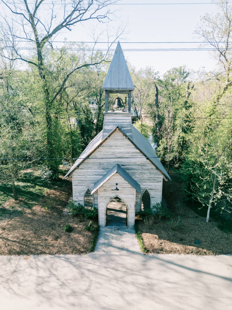 Aerial view of the historic chapel near Finley Farms Bridge – A rustic wooden chapel surrounded by lush greenery, setting the scene for Kandis and Andrew’s intimate gathering.