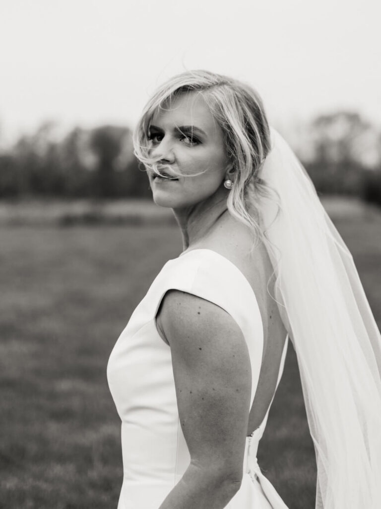 Black-and-White Bridal Portrait - A timeless black-and-white close-up of the bride looking softly into the distance, with strands of hair gently framing her face.