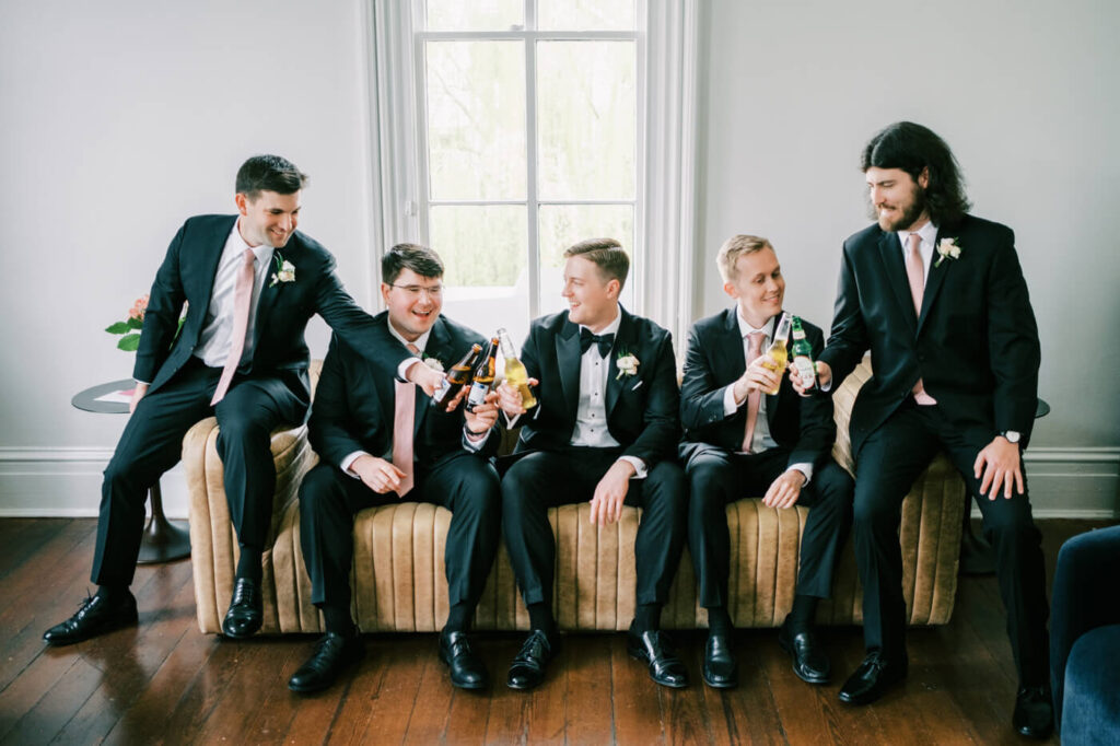 Groom having a toast with groomsment at the Merrimon-Wynne House.