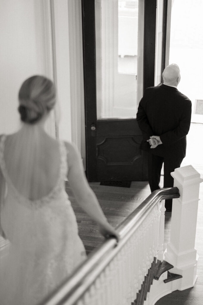 Bride walking to first look with father on the stairs at the Merrimon-Wynne House in Raleigh, NC.