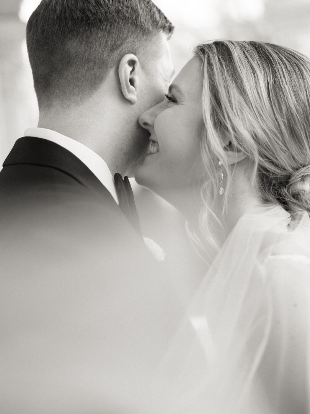 Bride and groom portraits on the Merrimon-Wynne House porch, with the bride’s veil softly catching the light.