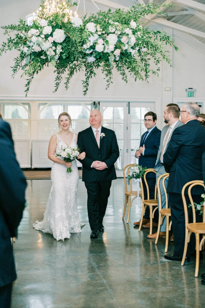 Bride walking down the aisle with father at the Carriage house at Merrimon-Wynne House.