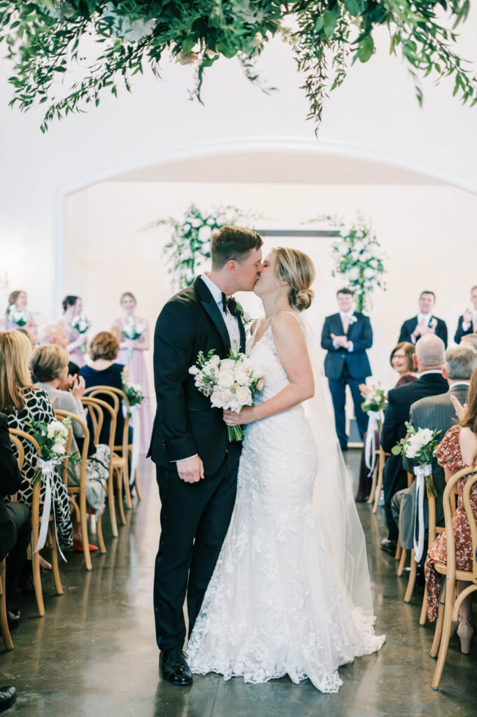 First kiss down the aisle at ceremony at the Carriage house at Merrimon-Wynne House