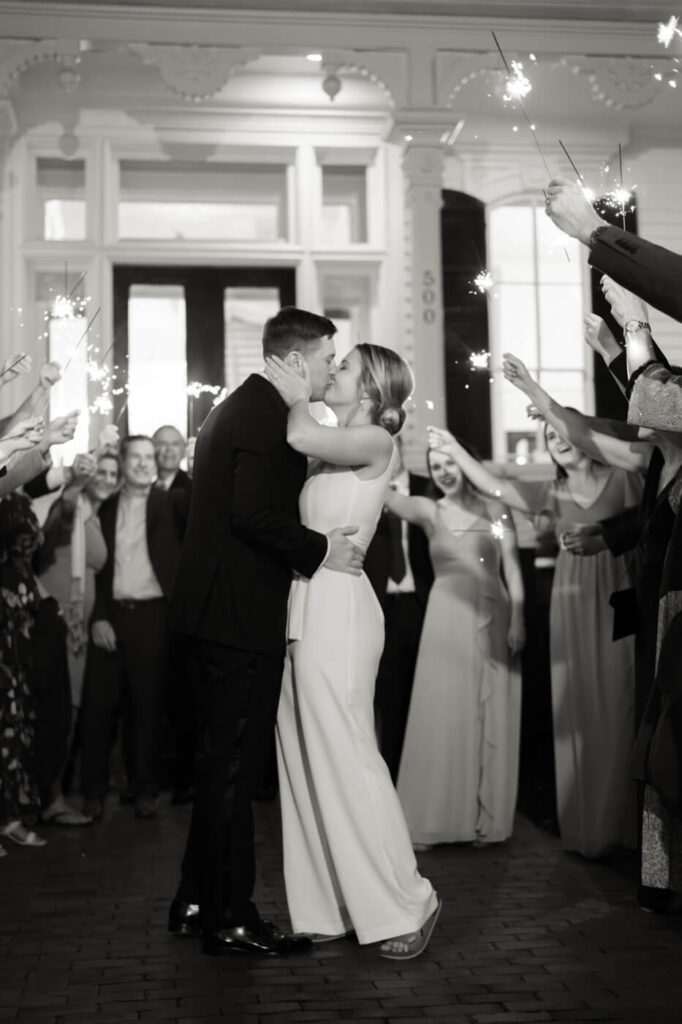 Bride & groom kiss during sparkler exit at Merrimon-Wynne House front steps