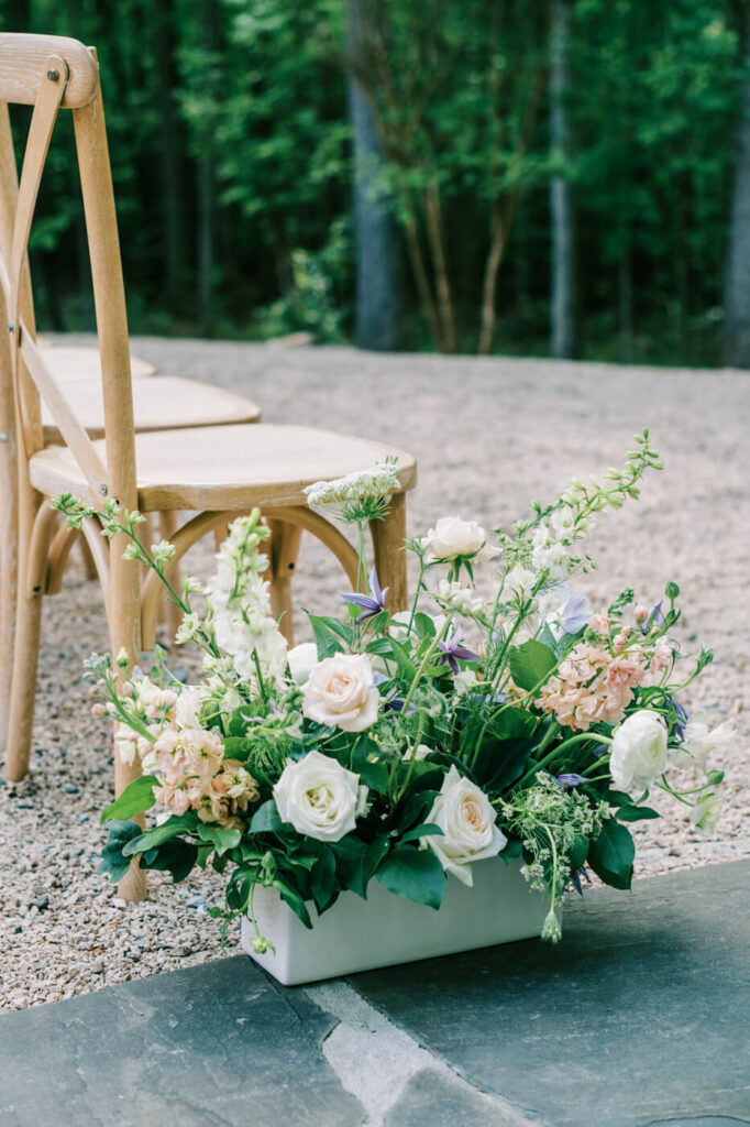 Aisle floral arrangement in a white vase featuring white roses, blush blooms, and soft greenery, adding a romantic touch to the Carolina Grove ceremony.