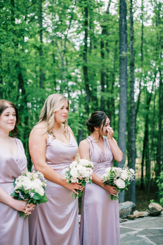 Bridesmaids’ Emotional Reactions – Bridesmaids in soft lavender satin dresses watch the ceremony, one wiping away tears of joy.