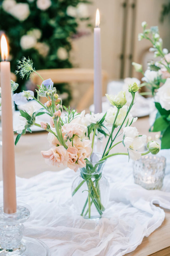 Candlelit Floral Centerpiece – Softly lit taper candles and pastel floral arrangements create a dreamy, intimate tablescape for the reception.