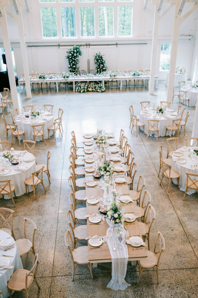 Overhead view of a beautifully styled wedding reception space with rustic wooden tables and romantic decor