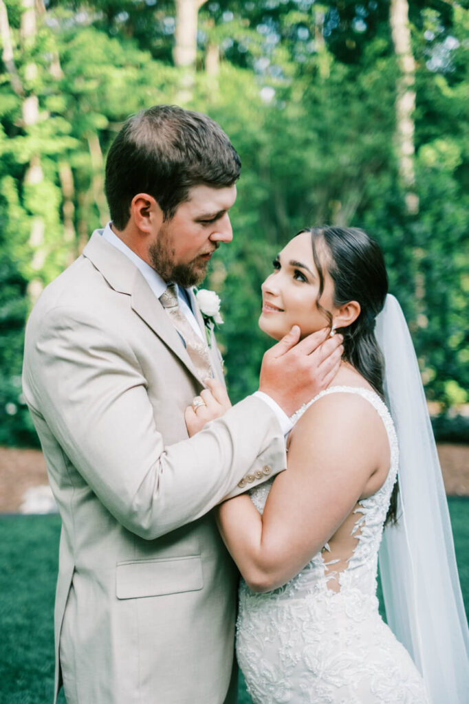 Bride and groom sharing an intimate moment outdoors, gazing into each other’s eyes