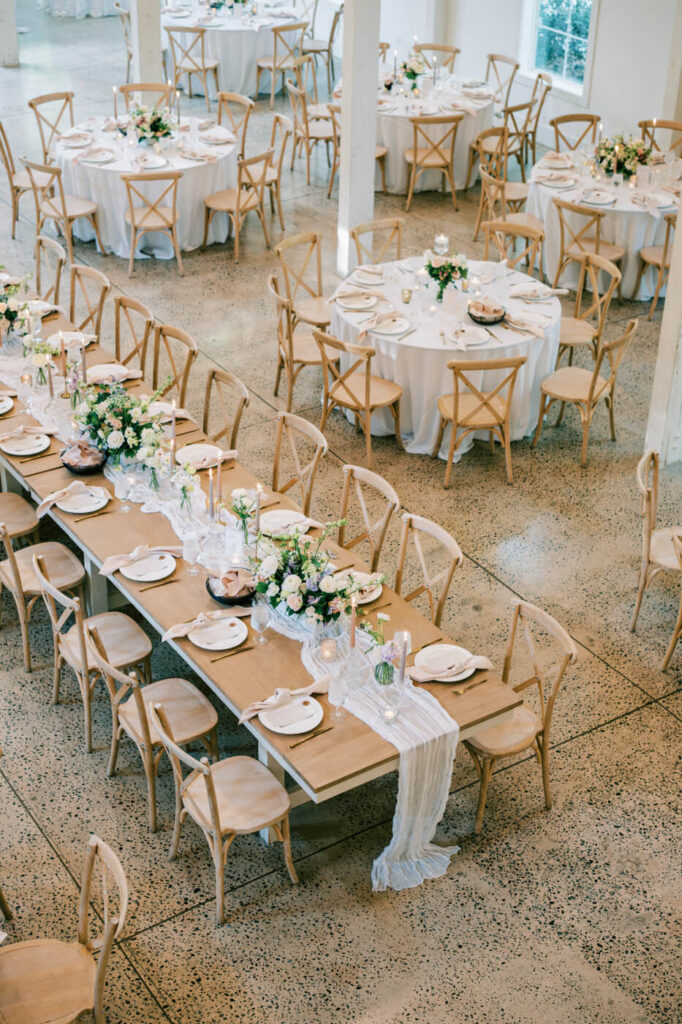 Overhead view of a beautifully styled wedding reception space with rustic wooden tables and romantic decor