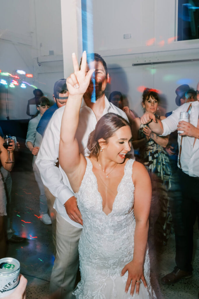 Bride and groom dancing with joyful energy – A fun, candid moment of the bride and groom celebrating together on the dance floor.