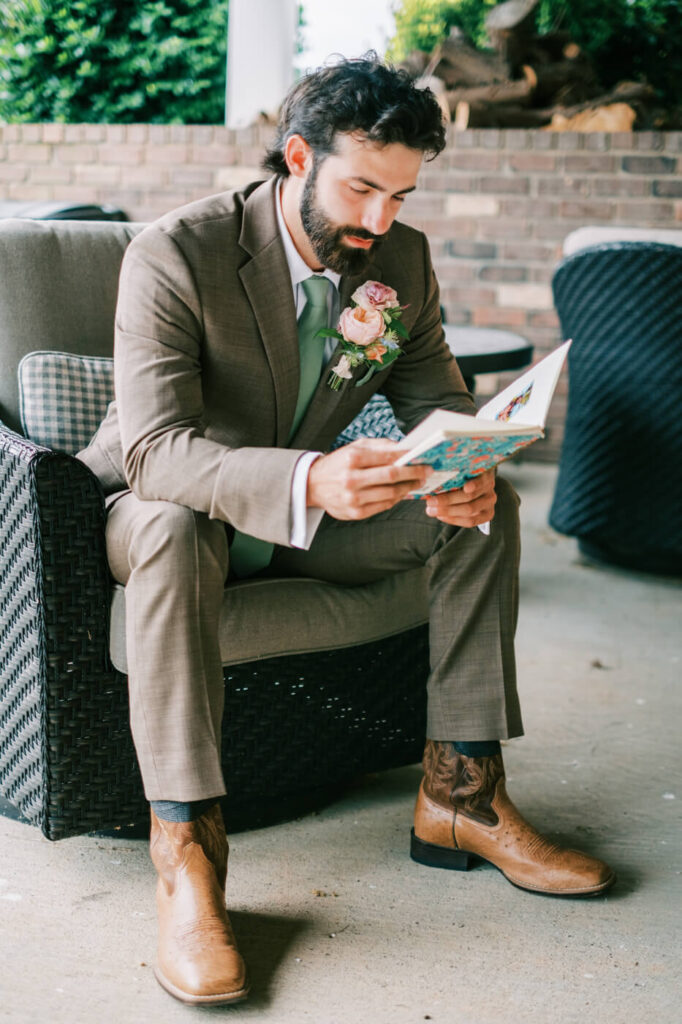 Groom in suit and cowboy boots reading vows, detail from an Asheville mountain wedding captured by The Reeses.