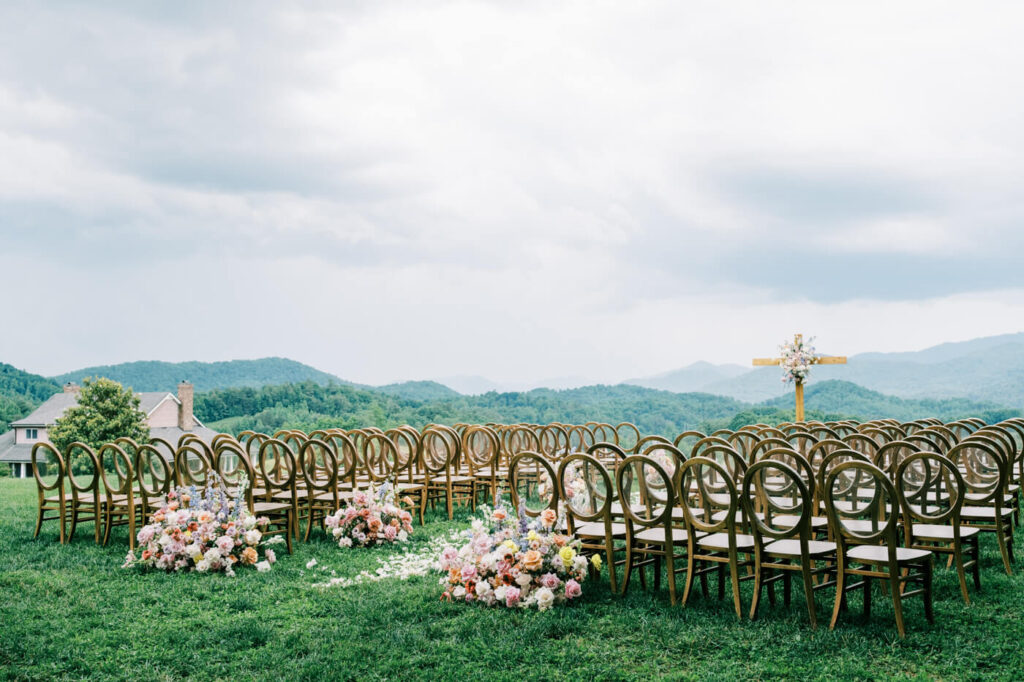 Ceremony setup with chairs and floral decor against mountain backdrop, part of an Asheville mountain wedding by The Reeses.