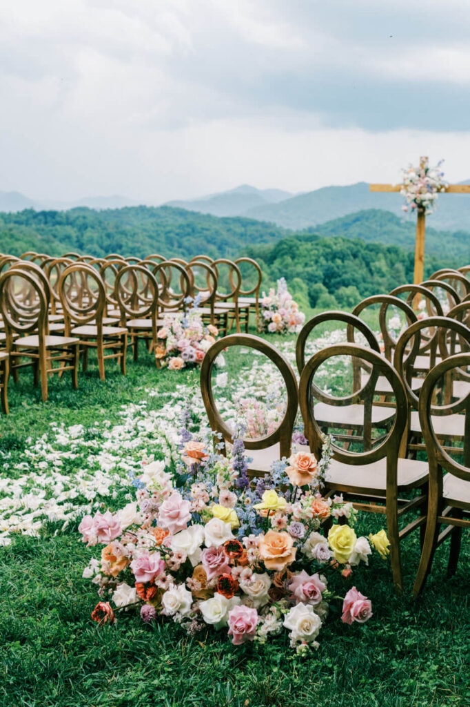 Floral arrangement with wooden chairs, part of an Asheville mountain wedding photographed by The Reeses.