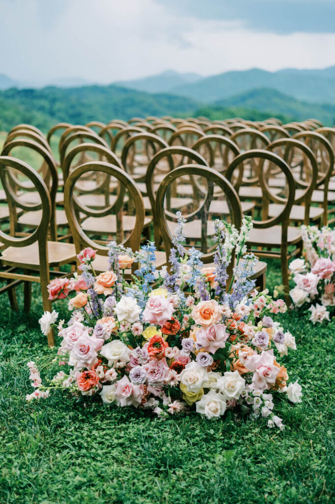 Floral arrangement with wooden chairs, part of an Asheville mountain wedding photographed by The Reeses.