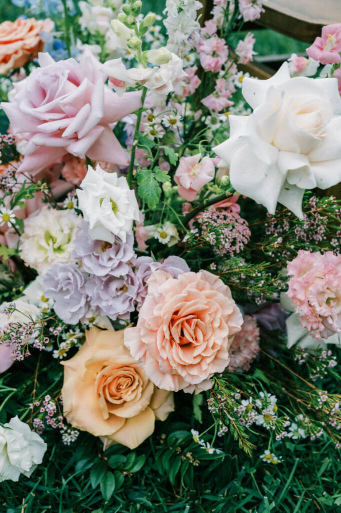 Close-up of floral arrangement along the aisle, featured in an Asheville mountain wedding by The Reeses.