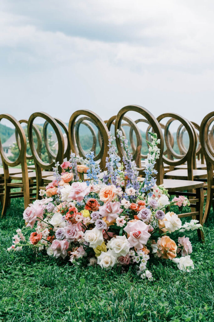 Floral arrangement with wooden chairs, part of an Asheville mountain wedding photographed by The Reeses.