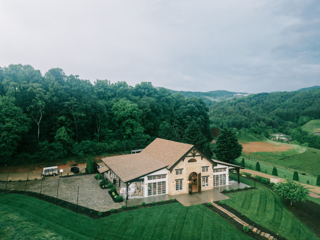 Aerial view of the wedding venue with mountains, part of an Asheville mountain wedding captured by The Reeses.