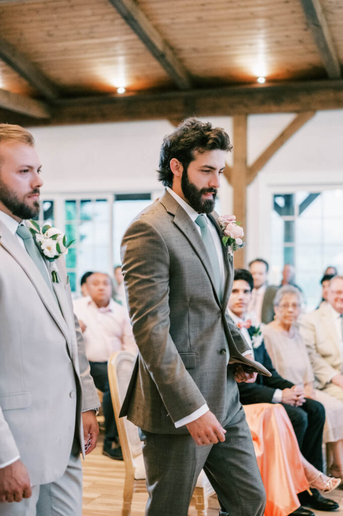 Groom walking into ceremony with groomsmen, part of an Asheville mountain wedding by The Reeses.