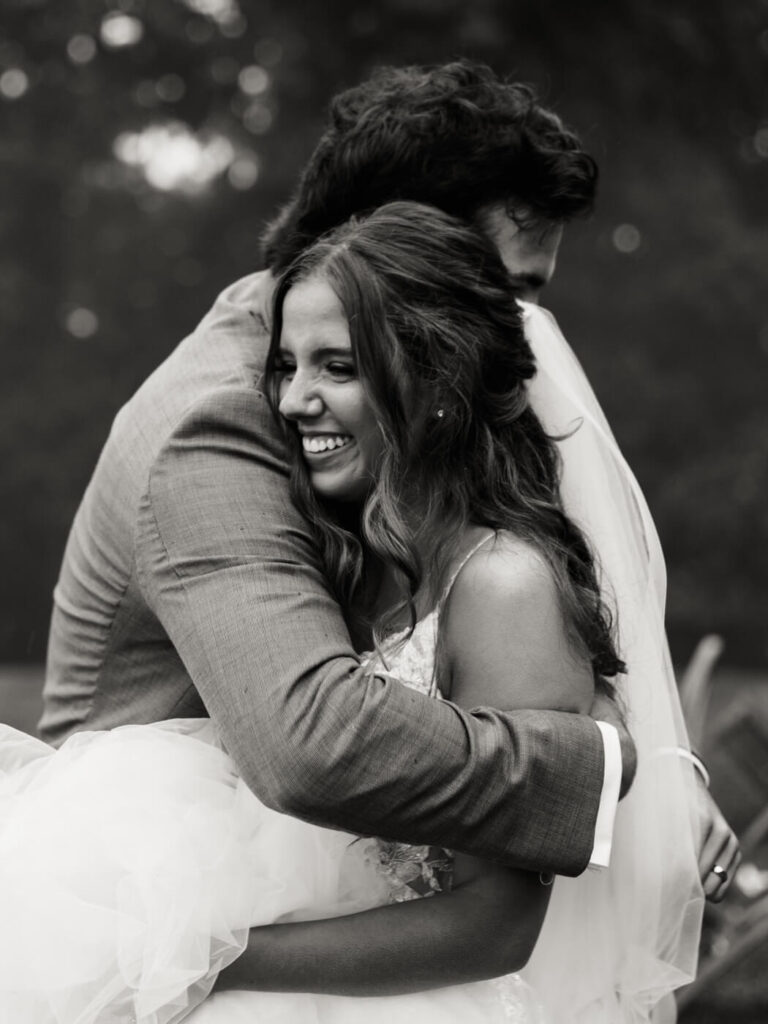 Bride and groom hugging in black and white, part of an Asheville mountain wedding captured by The Reeses.