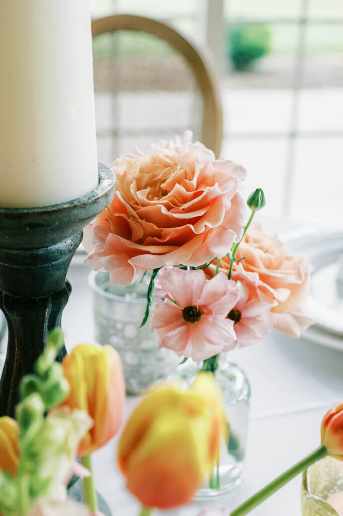 Close-Up of Peach Wedding Flowers and Candlelight – A detailed shot of blush and peach roses, accented by candlelight and warm-toned decor, perfect for an elegant Asheville wedding.