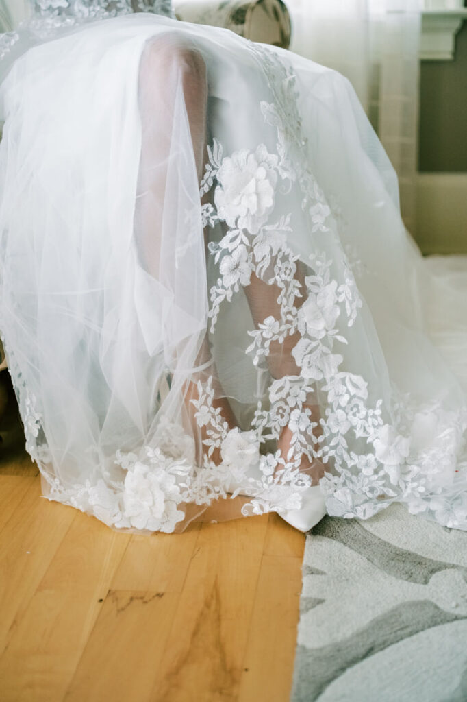 Close-up of a bride’s lace wedding dress with floral details, featured in an Asheville mountain wedding by The Reeses.