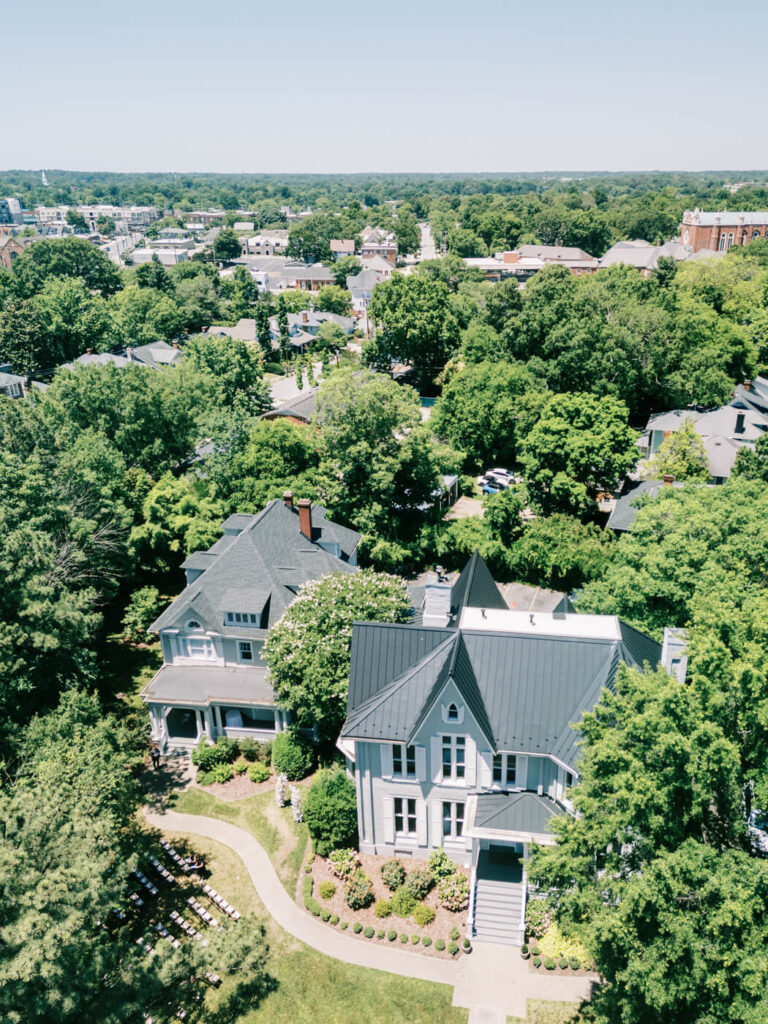 Aerial View of McAlister-Leftwich House – Stunning drone shot of McAlister-Leftwich House, a historic wedding venue in Greensboro, NC, surrounded by lush greenery and the city skyline.