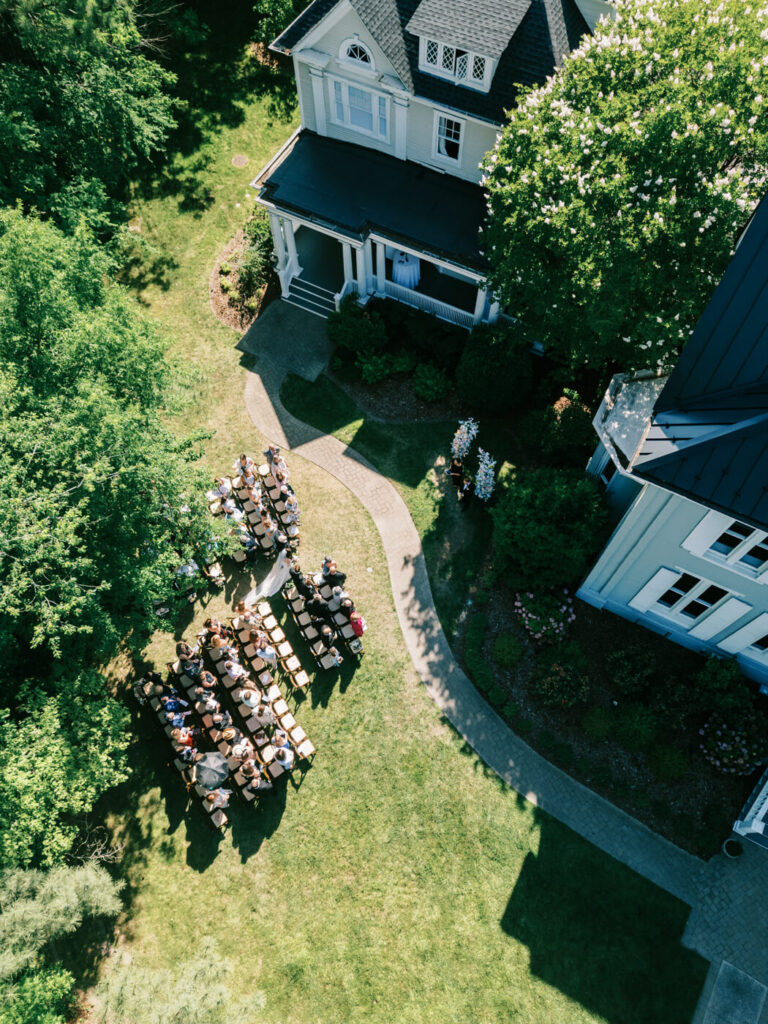 Aerial View of Outdoor Wedding at McAlister-Leftwich House – A stunning drone shot captures a picturesque wedding ceremony on the lush green lawn of the historic McAlister-Leftwich House in Greensboro, NC.