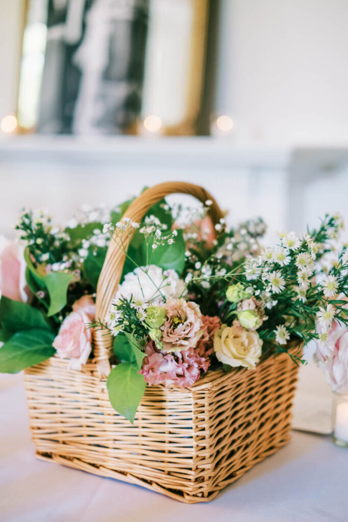 Romantic floral basket centerpiece at McAlister-Leftwich House wedding – A delicate wicker basket filled with blush and cream roses, baby’s breath, and lush greenery, enhancing the timeless elegance of a Greensboro, NC wedding.