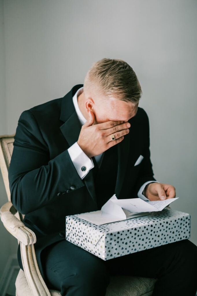 Groom wiping tears while reading a heartfelt letter from the bride before their Historic Robertson House wedding ceremony.