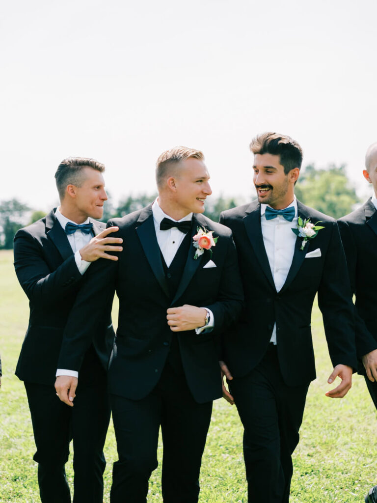 Groom laughing with his groomsmen before the ceremony – A candid moment between the groom and his groomsmen, capturing genuine laughter and camaraderie at this elegant wedding.