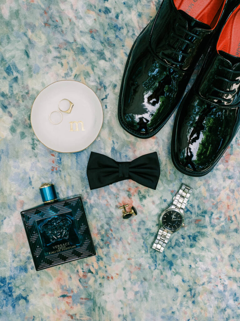 Groom’s wedding accessories, including bow tie, cufflinks, watch, and cologne, styled for an elegant Historic Robertson House wedding.