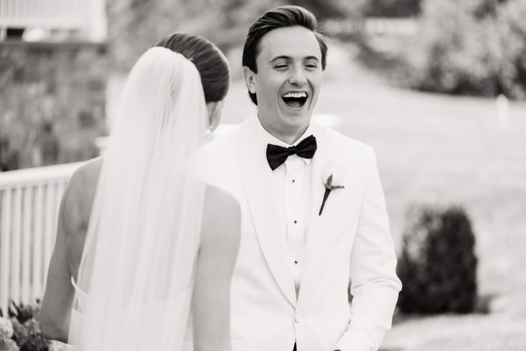 Groom laughs with joy during first look with bride at their summer wedding in New York